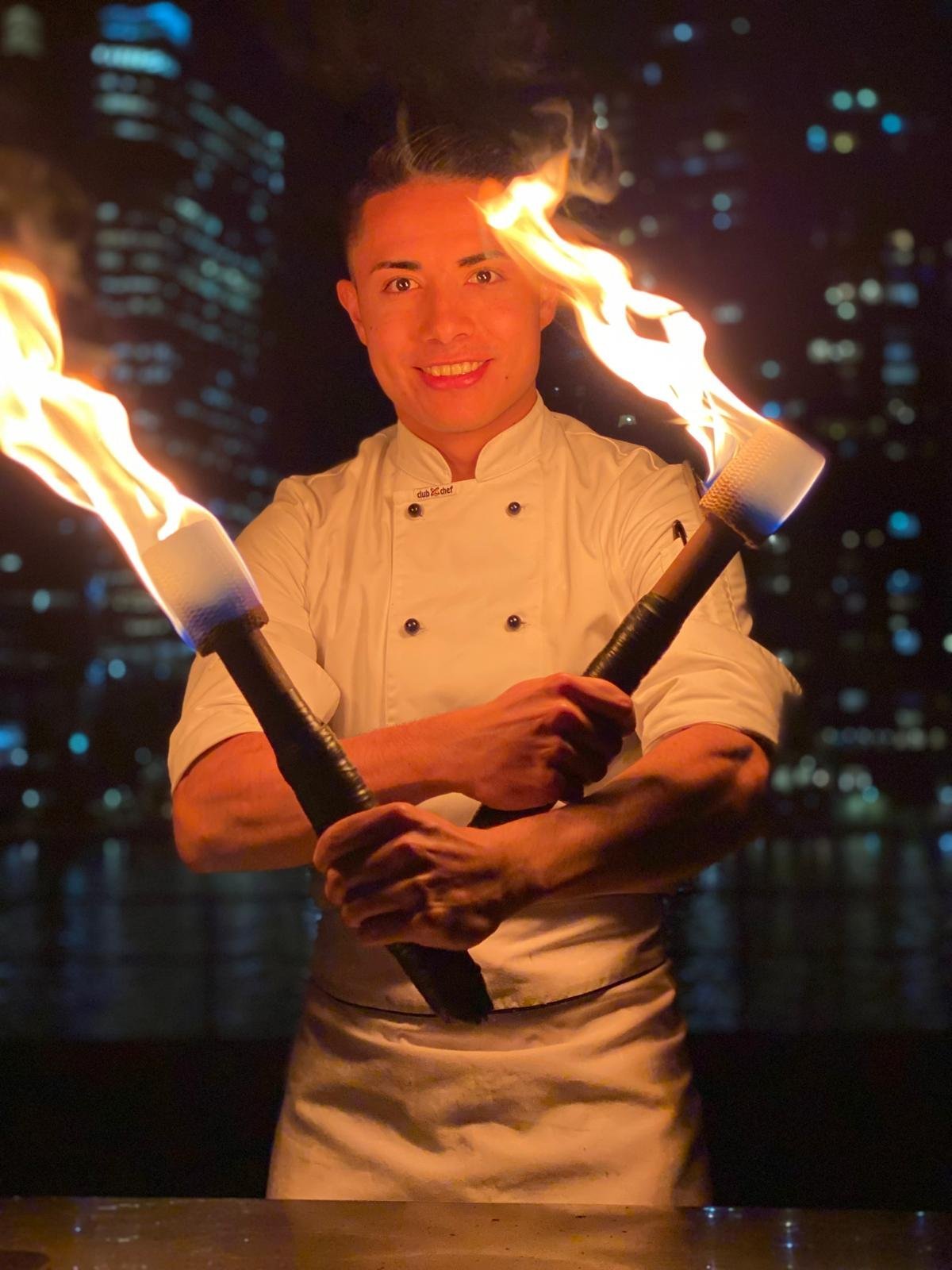 Chef Miguel holding a flaming torch at the teppanyaki grill