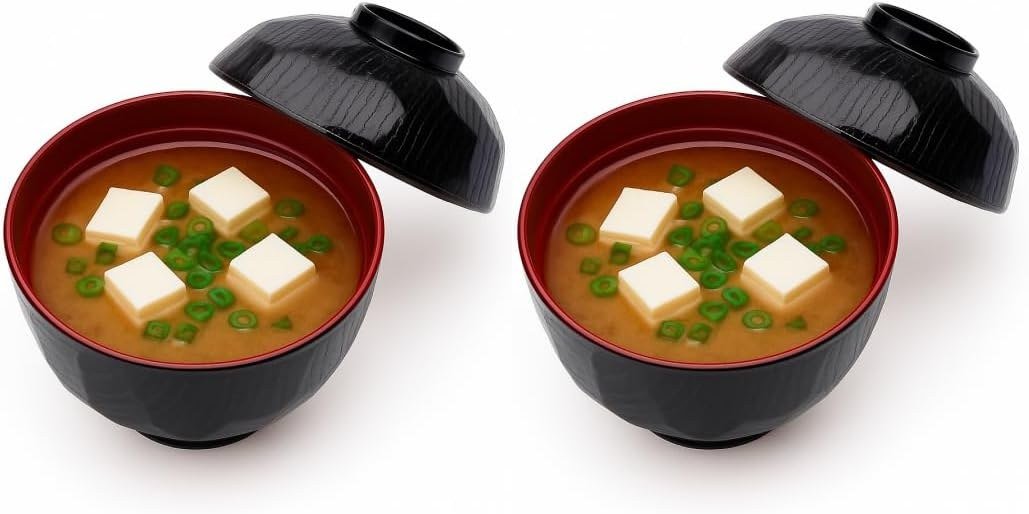 Black and red Japanese miso soup bowls with lids, filled with miso soup